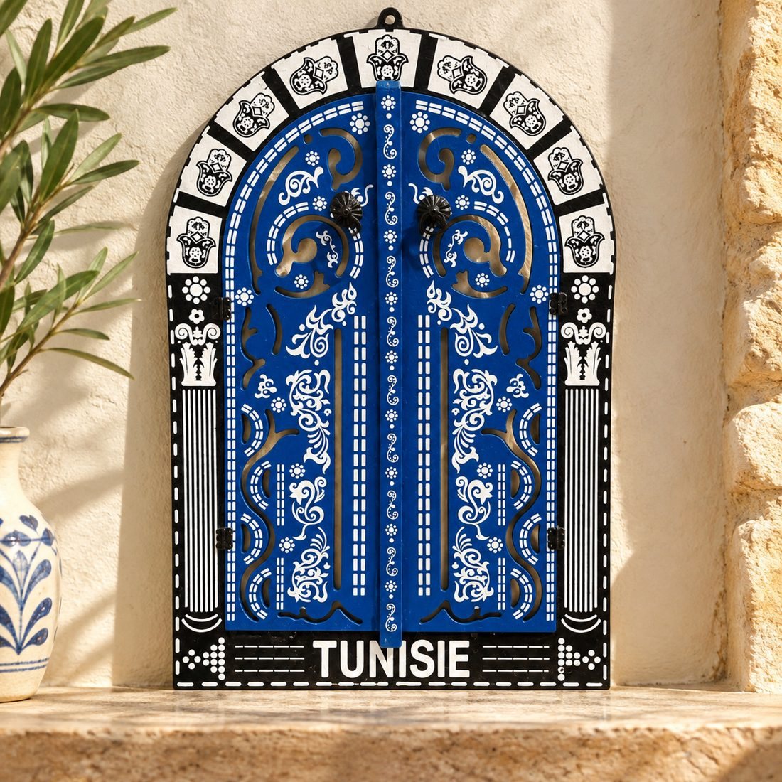 Grande porte bleue ornée contre un mur blanc